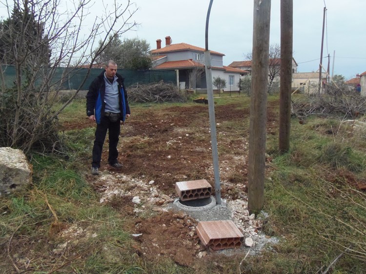 Roberto Fiducioso pored temelja za betonski stup i stari drveni stup nasred parcele (Z. STRAHINJA)